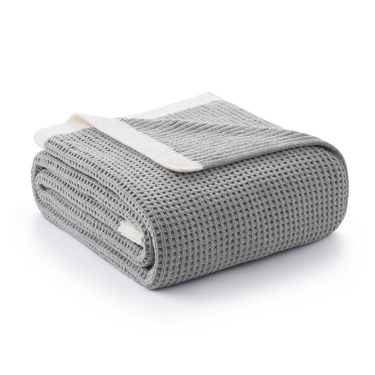 Amélie Home plaid face avant posé sur canapé, apporte confort et style