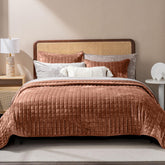 RECYCO couette terracotta présentée sur lit, finition luxueuse et chaude