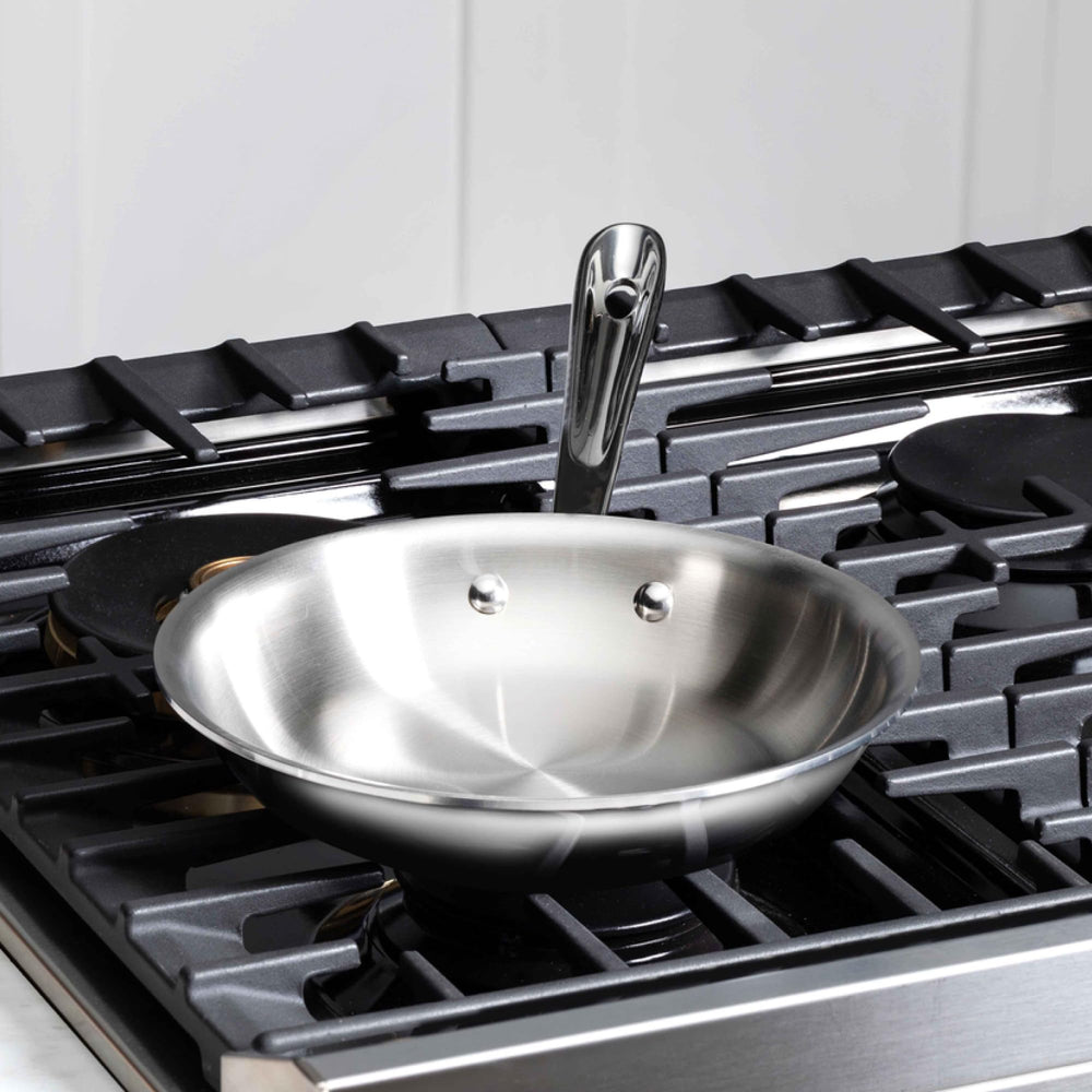 All‑Clad poignée rivetée offrant prise sûre et équilibre lors du sauté
