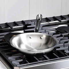All‑Clad poignée rivetée offrant prise sûre et équilibre lors du sauté