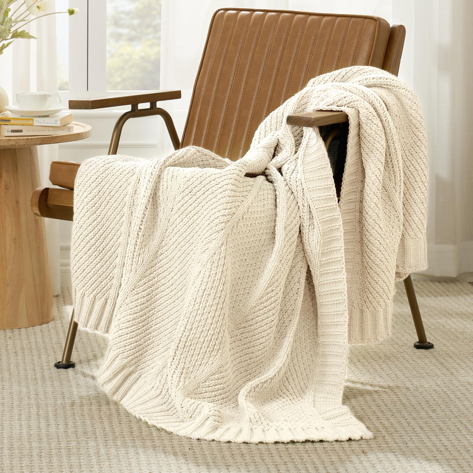 Amélie Home plaid plié sur un lit, rangement compact et joli rendu