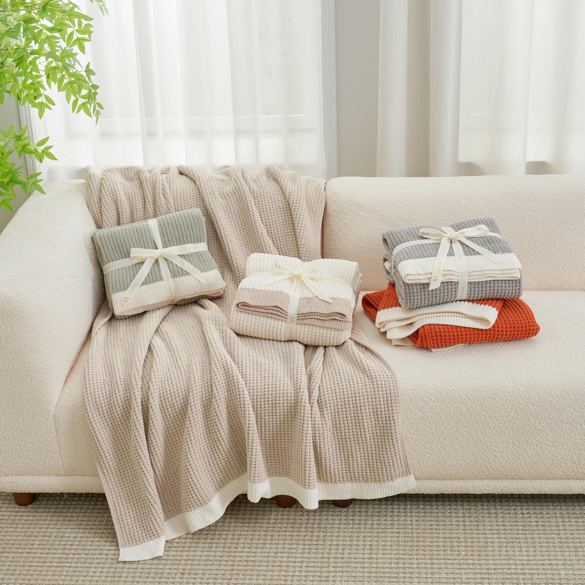 Amélie Home plaid drapé sur canapé ajoutant chaleur et style au salon