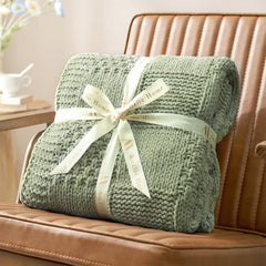Amélie Home plaid drapé sur canapé apportant ambiance cosy