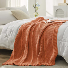 Amélie Home plaid plié sur canapé apportant confort et chaleur