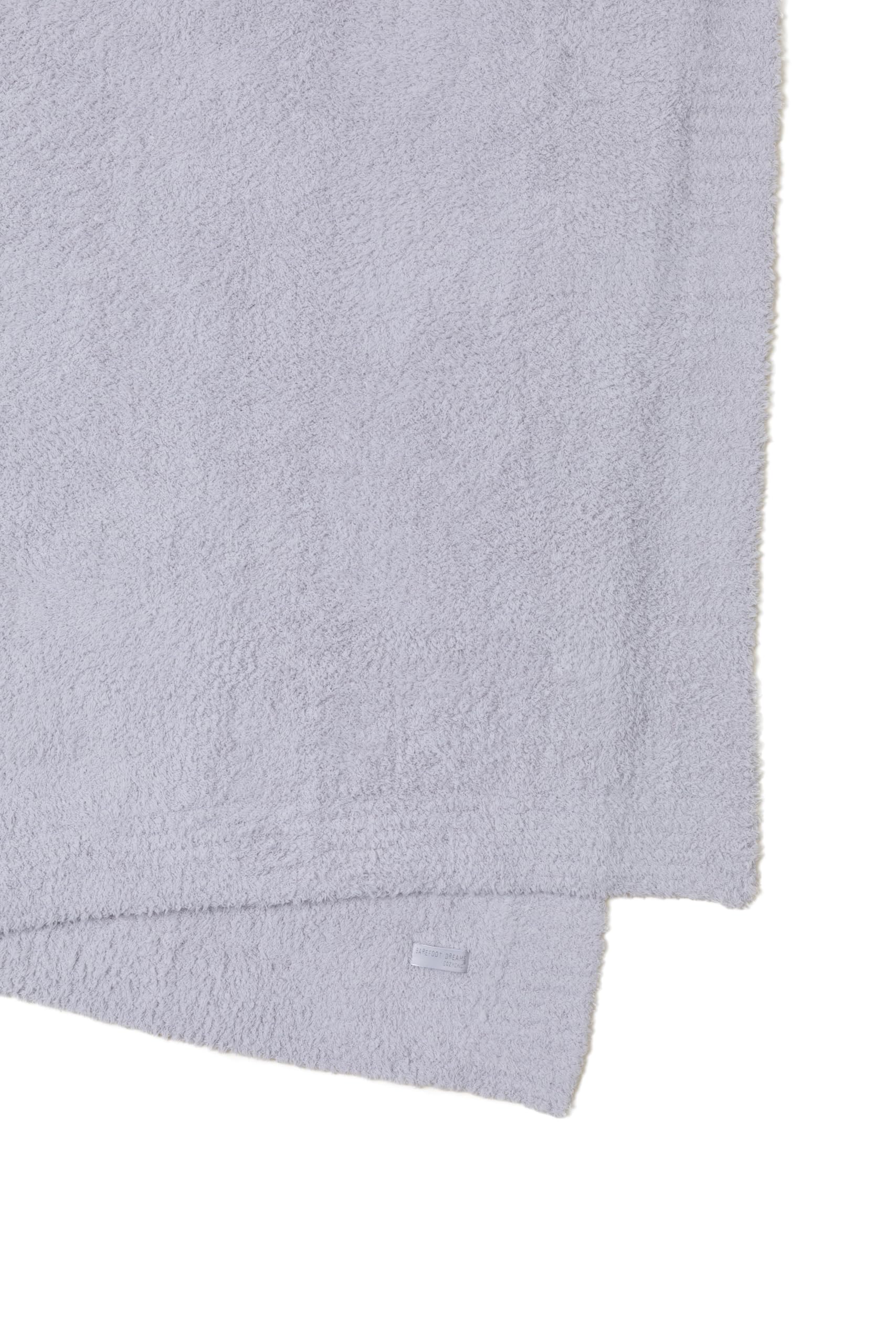 Barefoot Dreams plaid plié sur lit offrant confort esthétique et gain de place