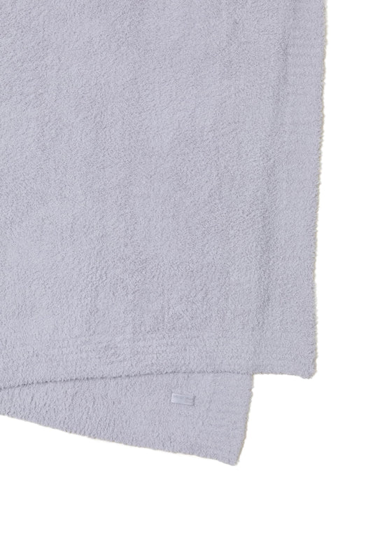 Barefoot Dreams plaid plié sur lit offrant confort esthétique et gain de place