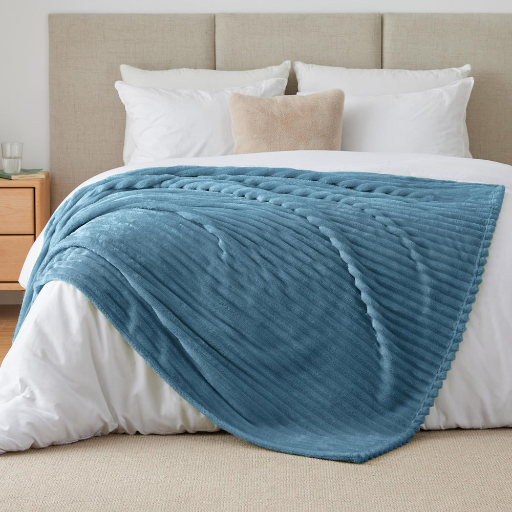 Plaid BEDELITE disposé sur lit créant ambiance chaleureuse et moderne