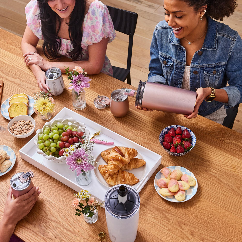 Scène de brunch avec BrüMate Togosa mat noir servant mimosas, style de table convivial