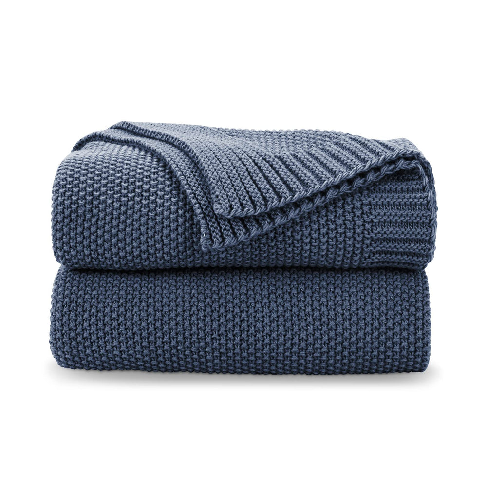 Couverture CozeCube Dusty Blue posée face visible, apporte chaleur décorative