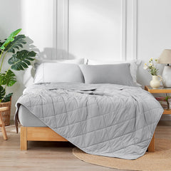 Cozy Bliss sur lit en situation déco illustrant confort frais et style gris