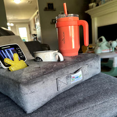 Cup Cozy Pillow en usage sur un canapé avec tasse et télécommande à portée