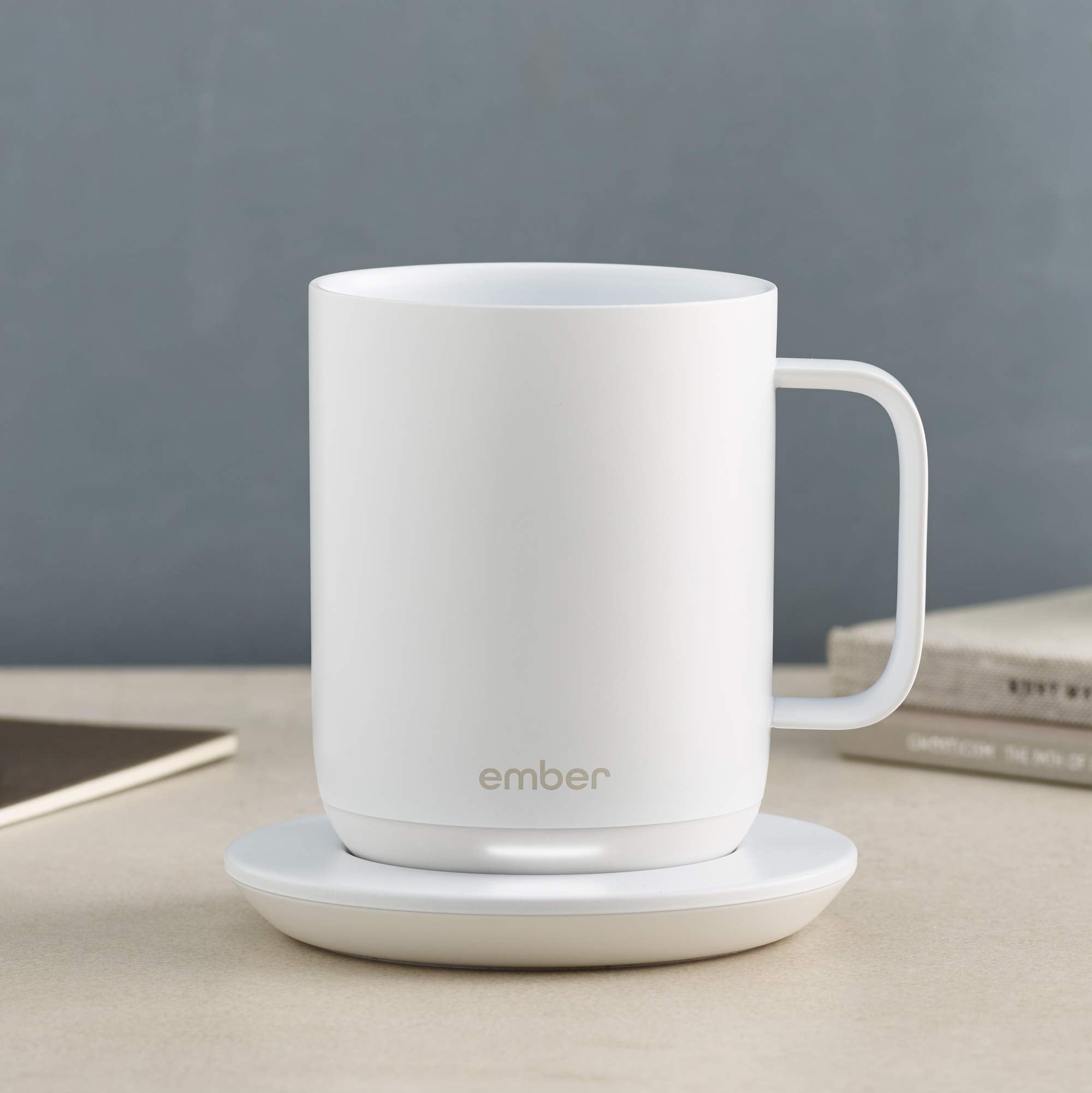 Ember Charging Coaster 2 en usage sur un bureau avec mug Ember, pratique pour garder la boisson prête