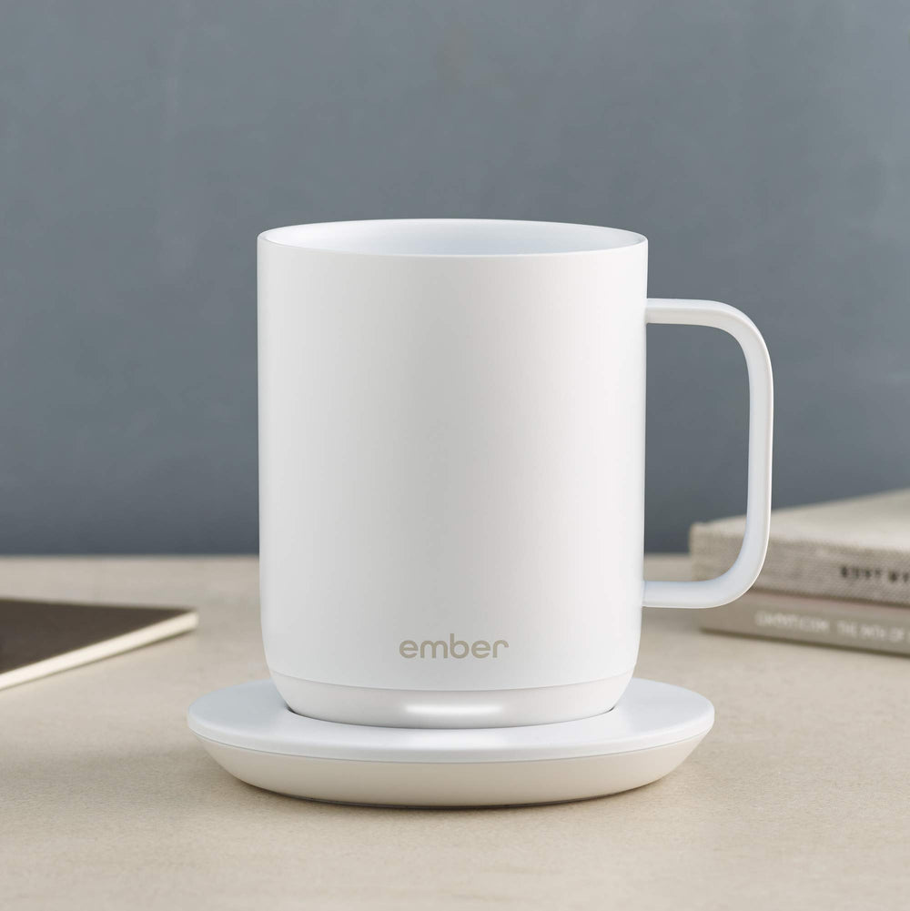 Ember Charging Coaster 2 en usage sur un bureau avec mug Ember, pratique pour garder la boisson prête