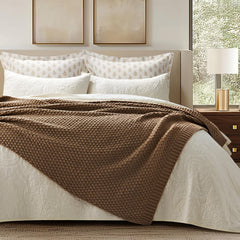 EverGrace plaid plié au pied du lit ajoutant texture et confort visuel