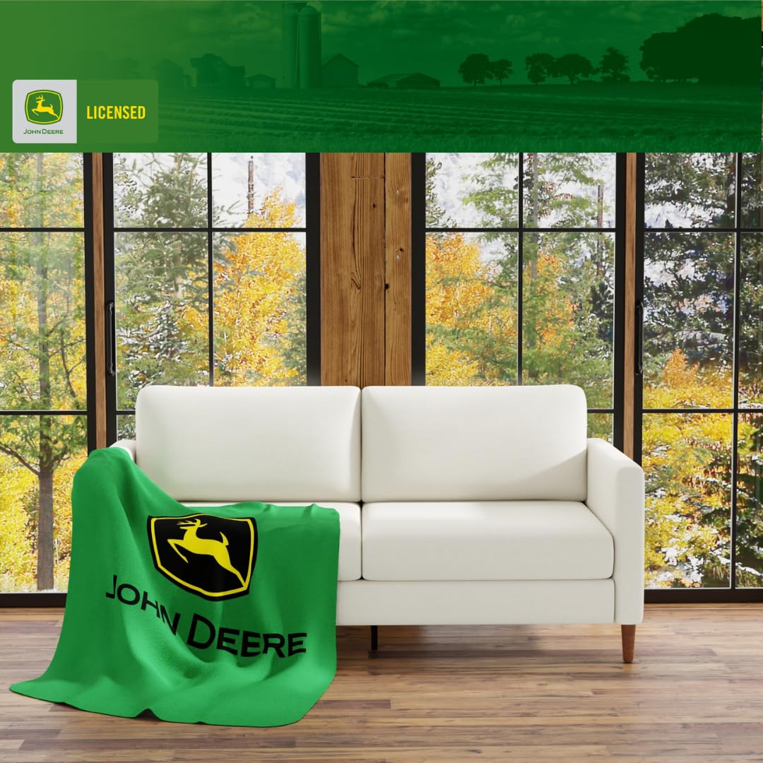 Franco John Deere plaid posé sur canapé apportant confort et chaleur immédiate