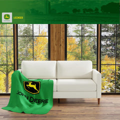 Franco John Deere plaid posé sur canapé apportant confort et chaleur immédiate