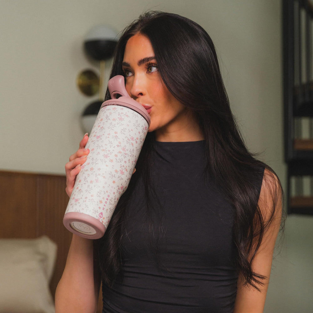 HydroJug à côté d'une main pour comparer taille 40oz et capacité réelle