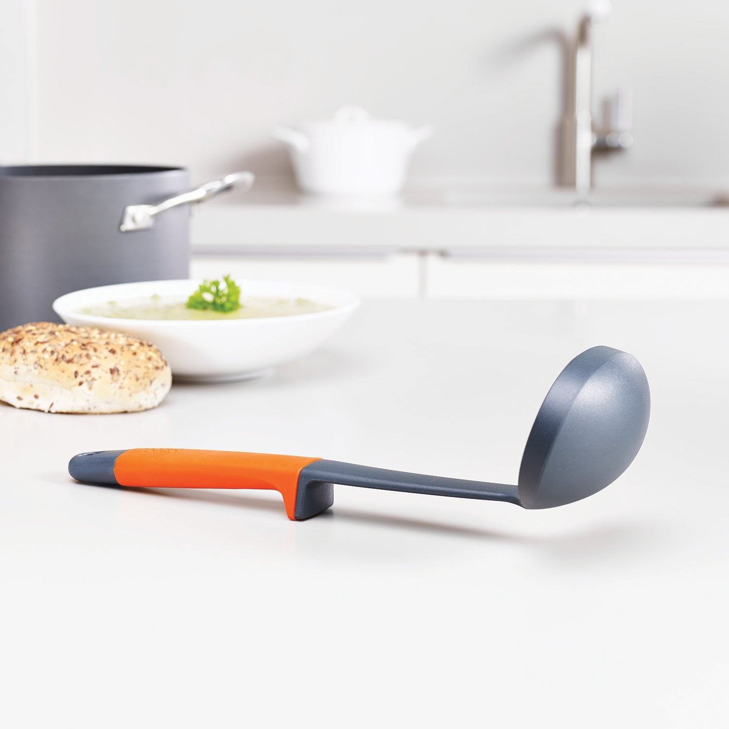 Joseph Joseph louche en nylon en utilisation près d'une casserole résistante à la chaleur