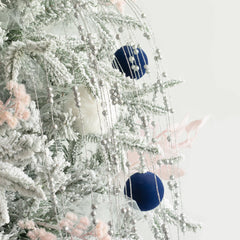 boules KI Store suspendues sur sapin illustrant décoration élégante