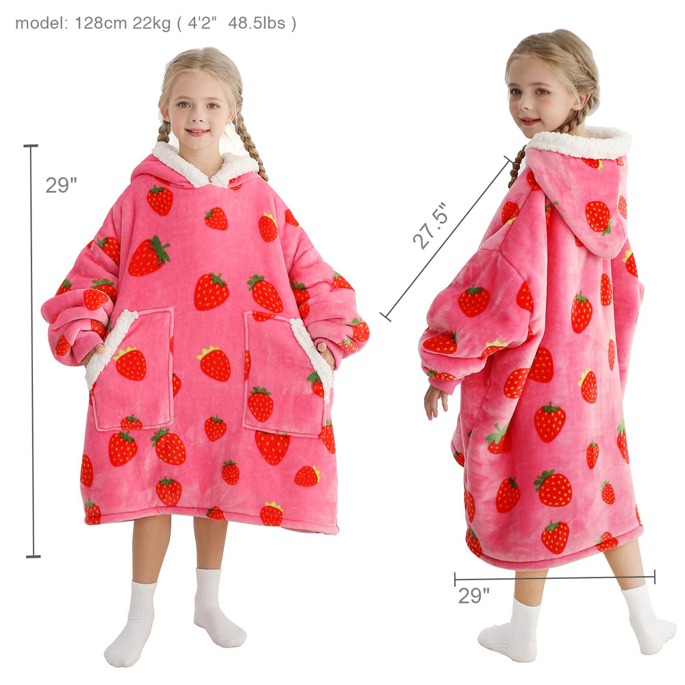 Kipswiza enfant portant la couverture-pull sur canapé apportant chaleur cosy