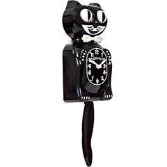Kit Cat Klock placé à côté d'un livre illustrant l'échelle et la taille compacte pratique