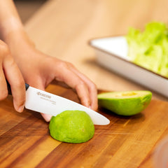 KYOCERA couteau en main en action découpant un fruit pour contrôle et confort