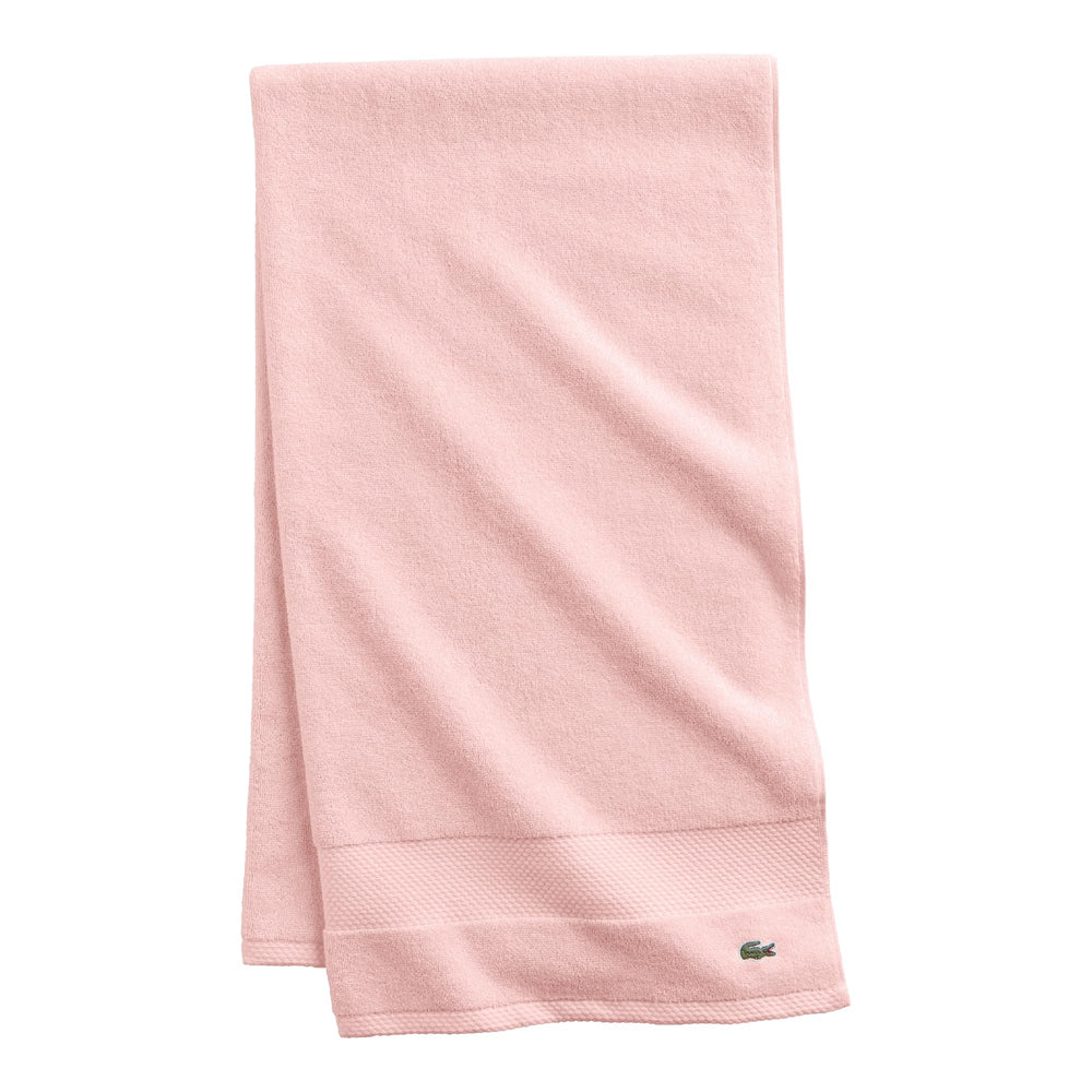 Serviette Lacoste Heritage rose clair pliée pour une présentation soignée et élégante