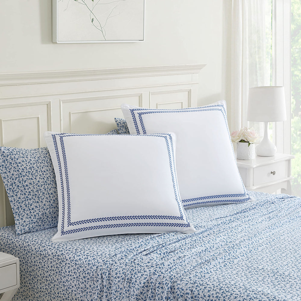 Laura Ashley taies posées sur lit stylisé pour rendu décoratif immédiat