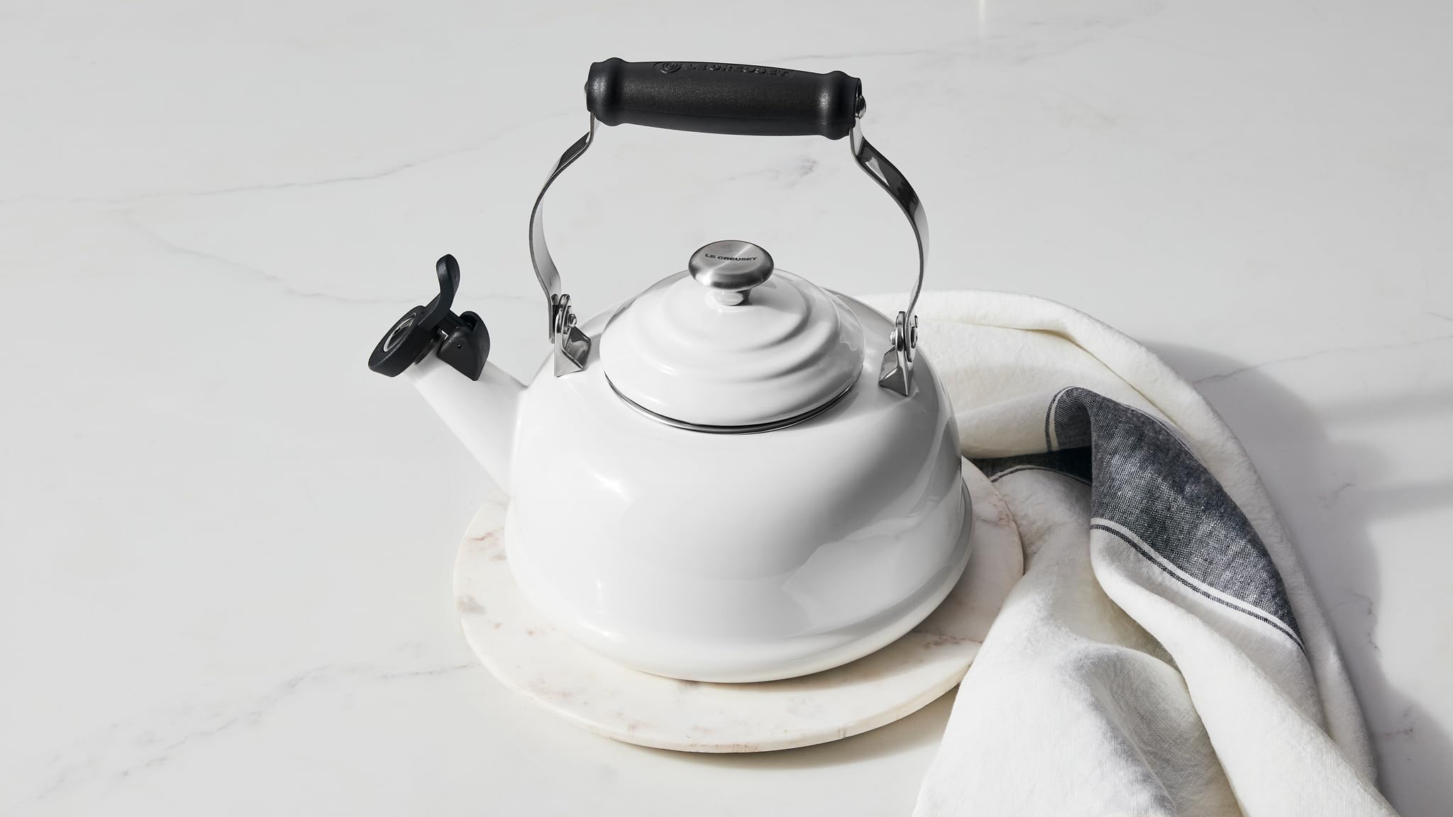 Le Creuset bouilloire Marseille à côté d'une tasse pour comparer la capacité 1,7 L
