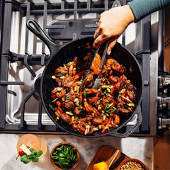 Lodge wok à côté d'une assiette pour montrer taille et capacité pratiques