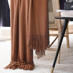 LOMAO plaid posé sur canapé illustrant protection de mobilier et ambiance cosy
