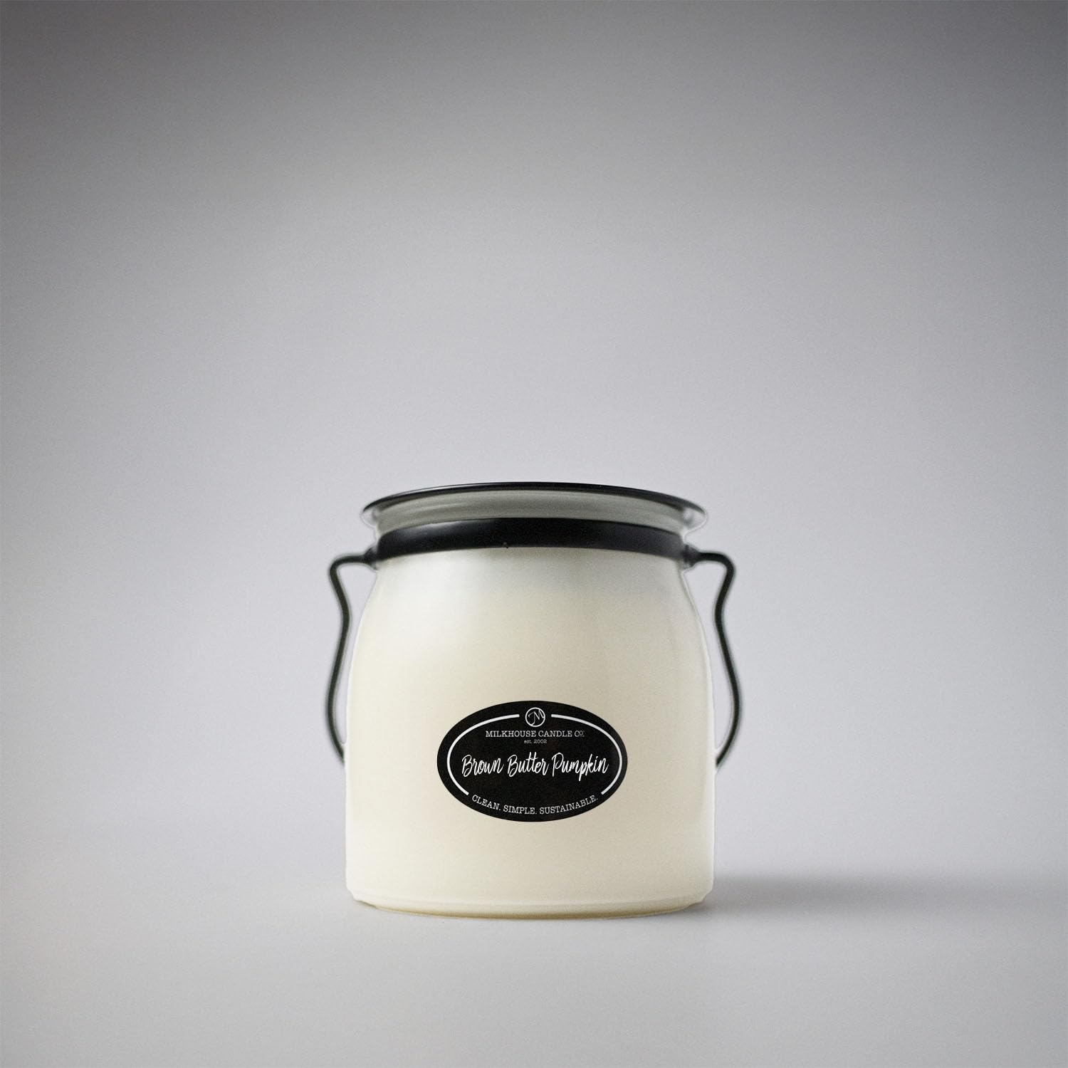 Milkhouse bougie placée sur table, apporte ambiance décorative accueillante