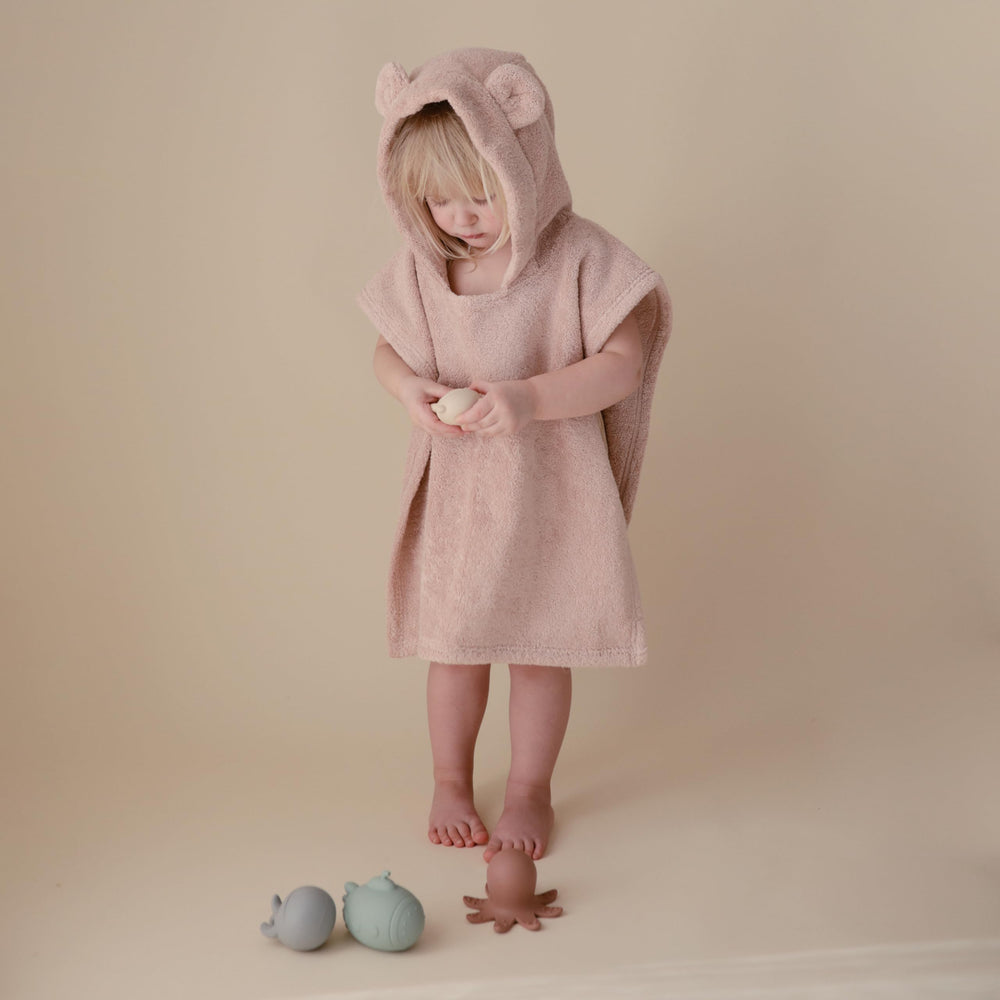 mushie poncho plié avec échelle de taille pour comparaison pratique