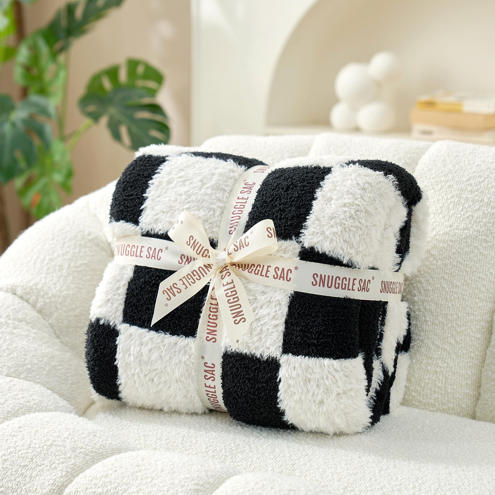 Snuggle Sac plaid disposé sur lit en décor, apporte style et chaleur