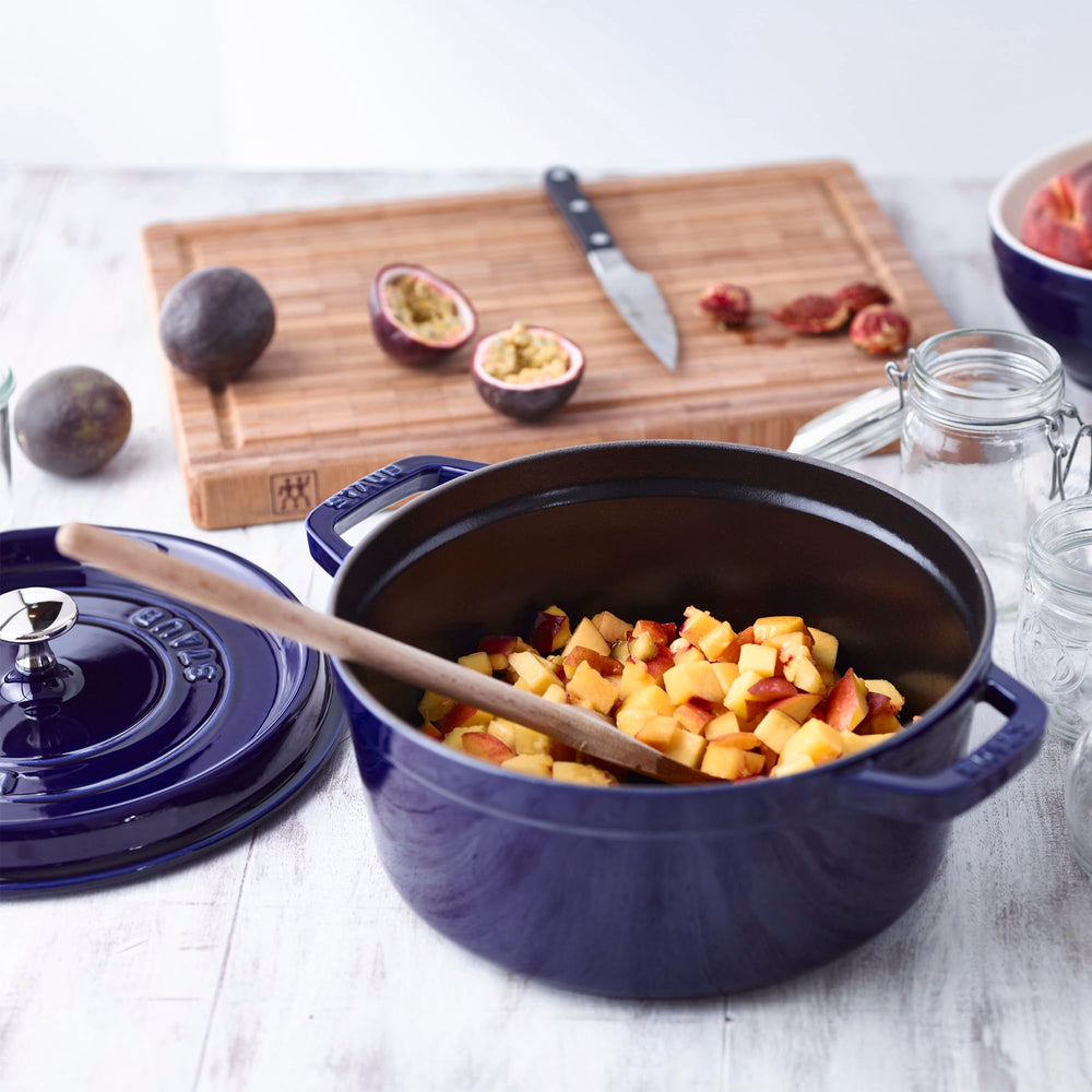 Staub cocotte servie sur table bleu foncé pour présentation raffinée des plats