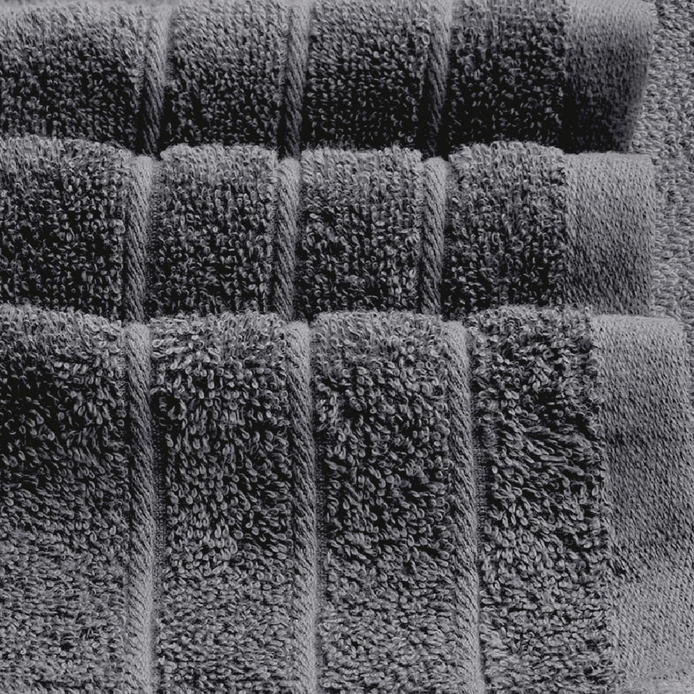 Tens Towels pliées à côté d'une règle pour indiquer la taille