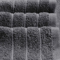 Tens Towels pliées à côté d'une règle pour indiquer la taille