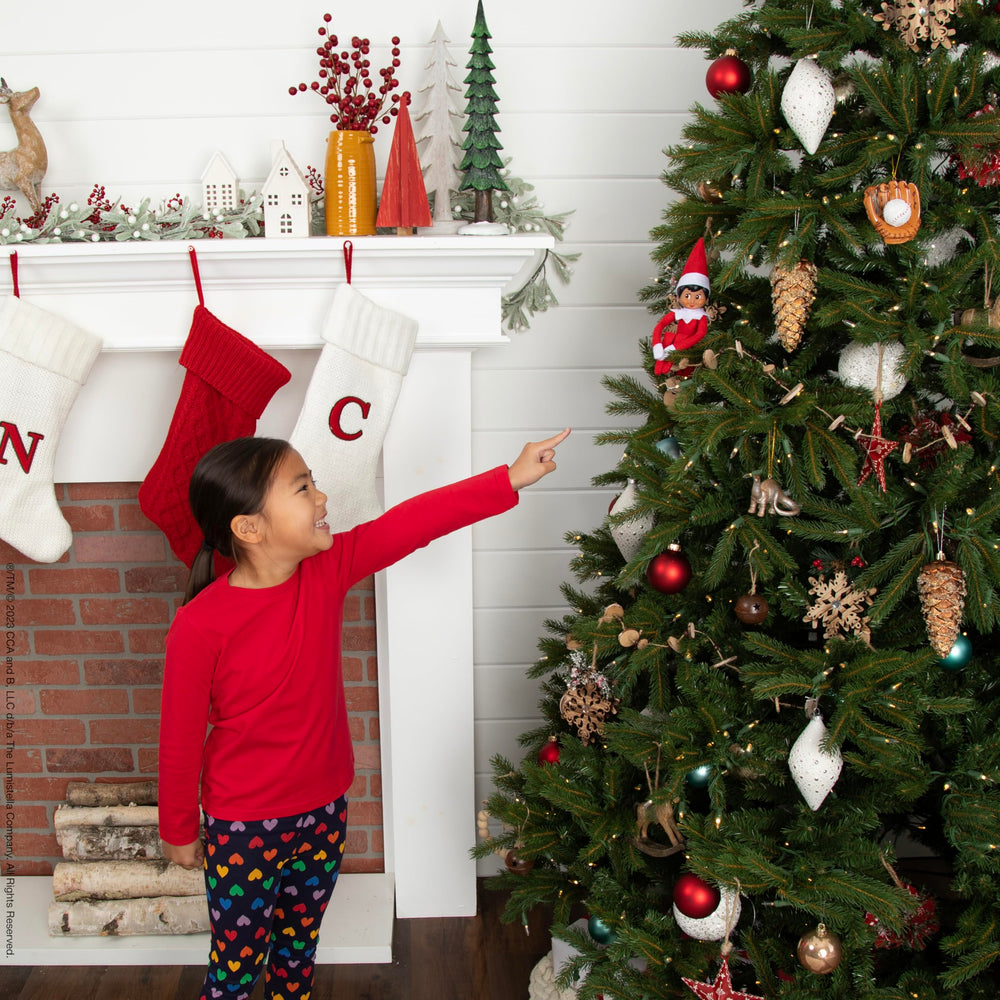The Elf on the Shelf scène familiale matinale avec enfants découvrant l'elfe heureux