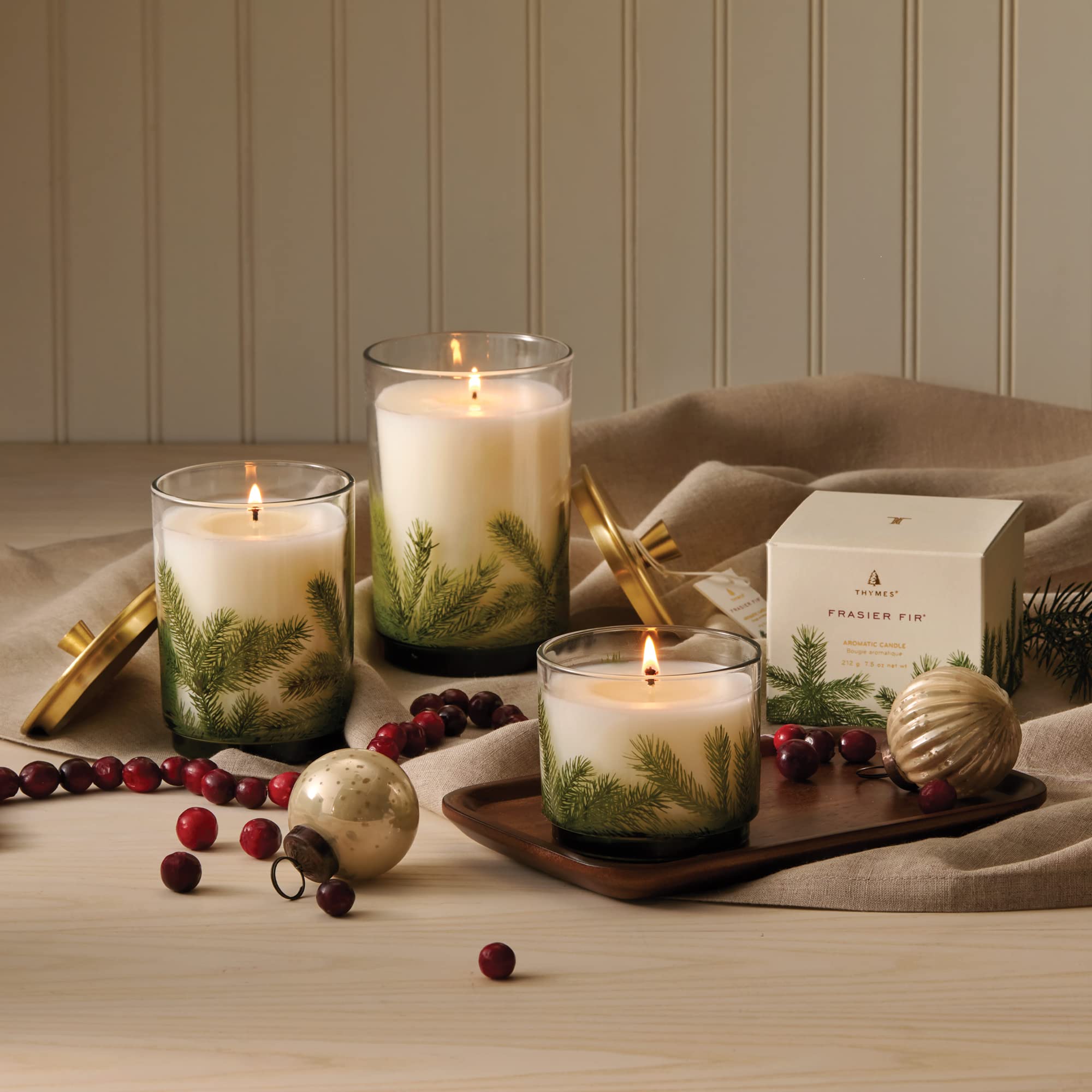 Bougie Thymes Frasier Fir posée sur une table de Noël créant une ambiance chaleureuse