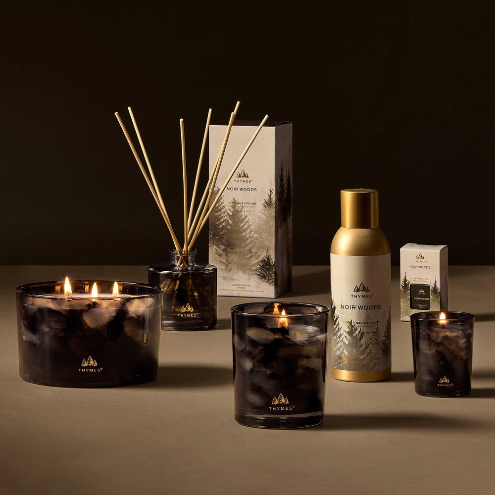 Bougie Thymes Noir Woods tenue en main pour démontrer la taille