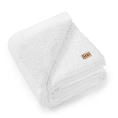Plaid UGG Nita devant blanc posé, apporte chaleur décorative