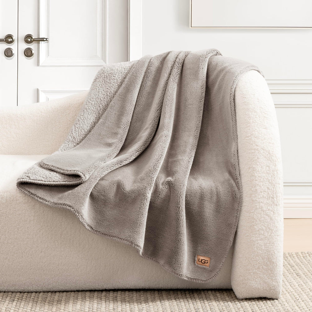 UGG plaid étalé sur lit apportant couche chaleureuse et esthétique raffinée