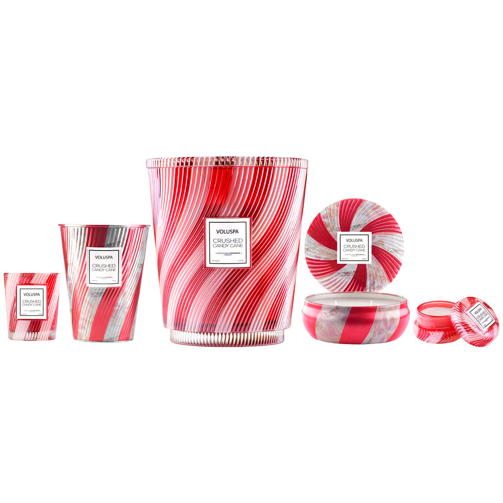 Voluspa bougie Crushed Candy Cane comparée à une tasse pour échelle, taille compacte