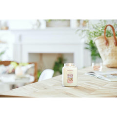Yankee Candle grand pot tenu en main pour illustrer la taille et la longue durée de combustion